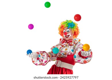 Funny clown juggler. Entertainer professional actor in colorful suit and wig juggling with colorful balls. Joker jester, pantomime, mime with clown whiteface makeup at event, kids party, circus