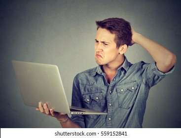 Funny clueless dumb guy having troubles with his laptop. Complicated technology concept 