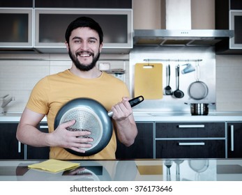 Funny Cooking. Adult Man In The Kitchen With Dripping Pot Like Guitar