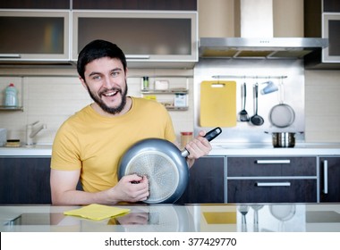 Funny Cooking. Adult Man In The Kitchen With Dripping Pot Like Guitar