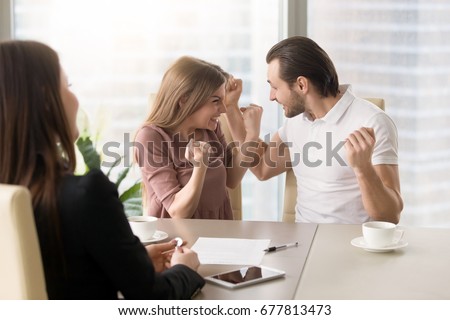Funny couple excited by purchasing real estate meeting with agent to get the keys, delighted young family enjoys buying first apartment, achieving goal, affordable property, home loan with low rates