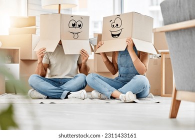 Funny, couple moving and boxes on head with faces, smile or emoji drawing on cardboard and new house, property or real estate. People, comic and box on body with happiness, crazy or joke in home - Powered by Shutterstock