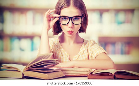 funny crazy  girl student with glasses reading books in the library - Powered by Shutterstock