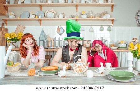 Funny crazy group of friends having fun and fool around with mad tea party concept