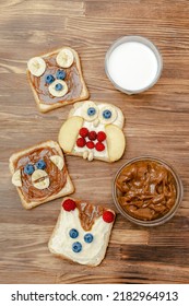 Funny Cute Bear,monkey,fox,owl Faces Sandwich Toast Bread With Peanut Butter,banana,blueberry,raspberry,milk. Kids Childrens Baby's Sweet Dessert Healthy Breakfast Lunch Food Art,close Up,top View.