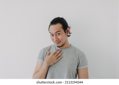 Funny cute shy Asian man in grey t-shirt on isolated white background.