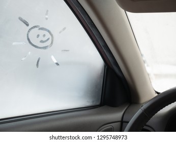 Funny Cute Sun Drawing On The Misted Frozen Glass On Car Side Window. Winter Season, Inside Auto Image