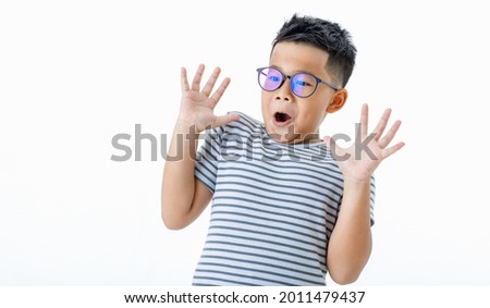 Funny cutout portrait of smart young healthy Asian boy wearing glasses and horizontal striped shirt surprisingly raising hands up as shocked, frightened, panic, and scared by unwanted terrified thing