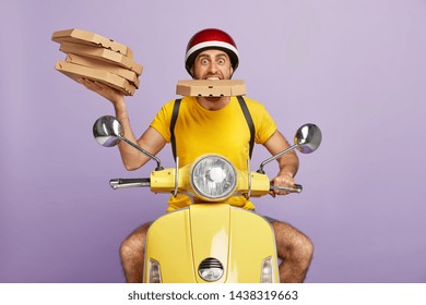 Funny deliveryman overload with pizza boxes, keeps one package in mouth, rides fast moped, dressed in special uniform, isolated on purple background. Food courier busy working, serves customers