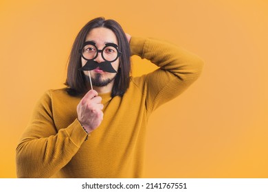 Funny Disguise Concept. Adult Caucasian Man Wearing Fake Glasses And Mustache Over Yellow Background. High Quality Photo
