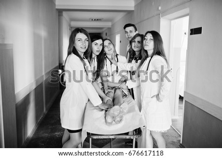 Funny doctors posing on the bed for ill patients in the hospital. Black and white photo.