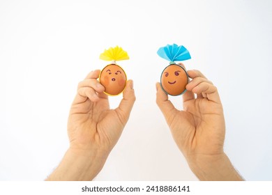 Funny Easter eggs in the hands of a man on a white background