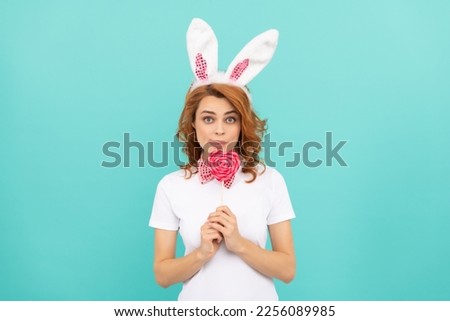 funny easter woman wear bunny ears hold heart lollipop