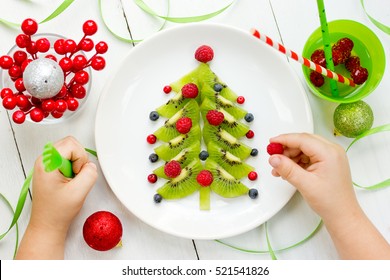 Funny Edible Christmas Tree For Kids Breakfast Or Dessert. Christmas Treats For Children. Baby Eating Christmas Food Composition Top View