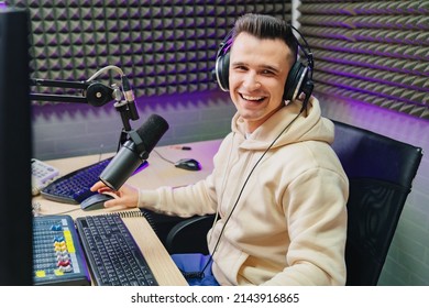 funny and emotional radio host with headphones on fun live streaming, reading news and messages from radio listeners into a studio microphone on a radio station