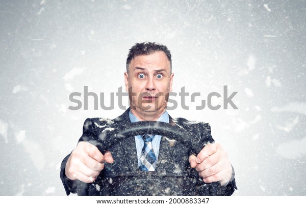 Funny emotionally\
frightened man in a jacket and tie, covered in bird feathers,\
holding a car steering wheel. Flying feathers on a gray background.\
Ripped chicken coop\
concept