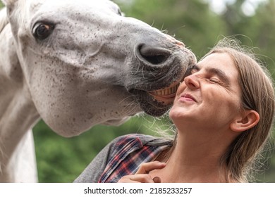 Funny equestrian team scene: A horse showing a kissing trick on command. Horse and owner having fun and joy - Shutterstock ID 2185233257