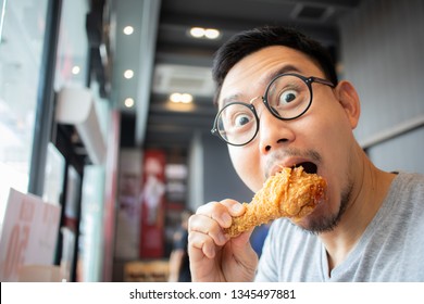 Funny Face Of Asian Man Eat Fried Chicken In The Franchise Cafe.