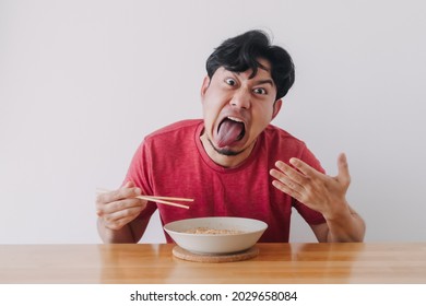 Funny Face Of Asian Man Eat Very Hot And Spicy Instant Noodle.