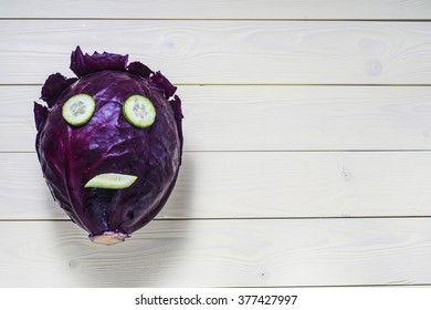 Funny Face Made Of Red Cabbage And Cucumber On Yellow Wooden Background, Flat Lay