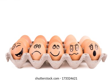 Funny faces painted on brown eggs in a tray - Powered by Shutterstock