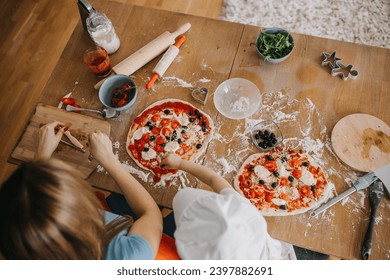 Funny family daughter and mother making pizza for dinner at the kitchen. Happy family together. - Powered by Shutterstock