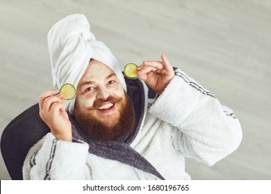 Funny Fat Bearded Man With A Cosmetic Mask On His Face In Bathrobe Towel On His Head On His Face Resting Against A Gray Background