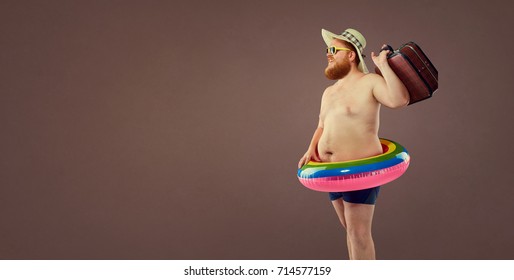 Funny fat bearded man with a suitcase in a hat and glasses on va