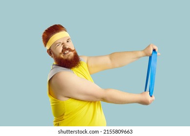 Funny fat guy trying to do fitness exercise with elastic band. Studio shot of large, big, stout man in yellow retro sweatband holding resistance loop and making funny grimace. Sports workout concept
