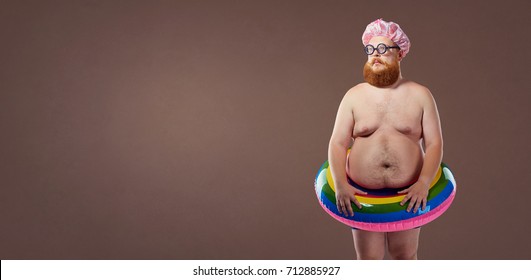 Funny fat man in bathing suit in an inflatable circle.