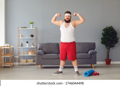 Funny Fat Man In Red Shorts And White T-shirt Smiling Doing Exercises In The Room