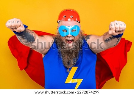 Funny fat man with superhero costume acting as superhuman with superpowers, portrait on colored background
