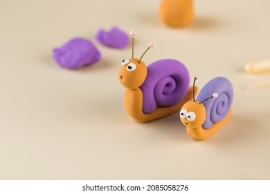  Funny figurines of a snail made of polymer clay. Copy space.
