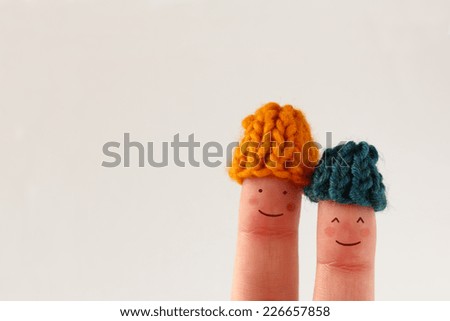 Funny finger people couple smiling with red cheeks wearing knitted woolen hats