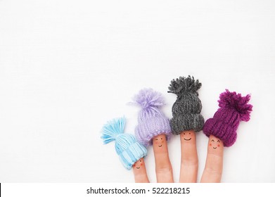 Funny finger people family couple smiling with red cheeks wearing knitted woolen hats under snow