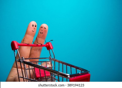 Funny fingers shopping at supermarket with red cart trolley on blue background