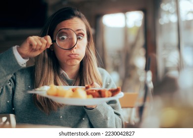 
Funny Food Critic Checking the Restaurant Dish with a Magnifying Glass. Picky eater analyzing the ingredients in a meal course
 - Shutterstock ID 2230042827