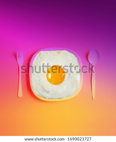 Funny fried eggs on a yellow-pink gradient background. The concept of a good day and mood for Instagram stories