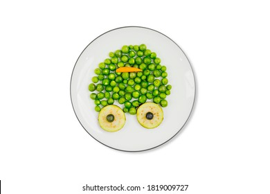 Funny Frog Animal Face Made Of Peas And Sliced Eggplants On The Plate Over The Table. Isolated On White Background