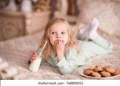 Funny Girl 3-4 Year Old Eating Cookies And Drinking Milk In Bed. Good Morning. Breakfast. 