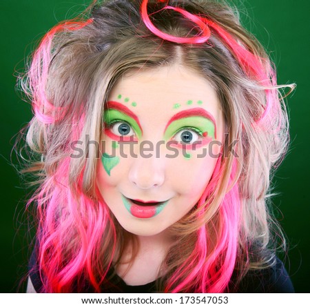 funny girl with crazy make-up over green background