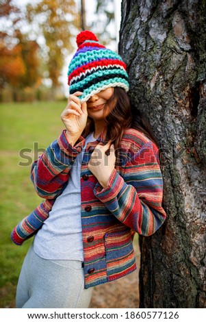Funny Girl With A Cute Knitted Hat In Autumn Park
