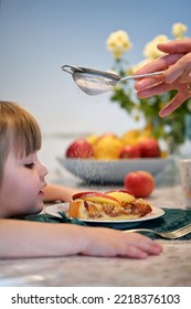 Funny Girl Eating Apple Pie Cake At Home. Sprinkled With Sugar Powder.