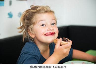 Funny Girl Eating Bread Roll With Dark Marmelade