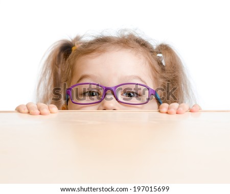Funny girl in eyeglasses hiding behind a table