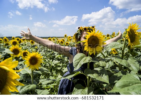 Funny girl in the middle of a sunflower field