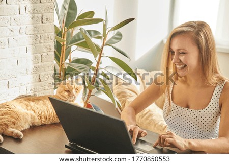 Funny girl professional laughter sitting with a laptop on a home office Desk, positive European woman fun to enjoy sincere emotions laughter study work on a PC. Quarantine, remote work.