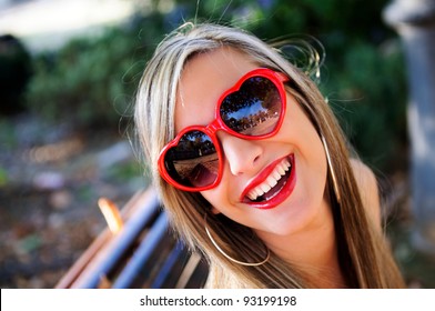 Funny Girl With Red Heart Glasses In A Park