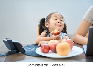 Funny Girl Sits Table In Front Of Phone And Eats Peach