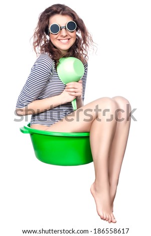 Funny girl sitting in a green wash rides on a white background.